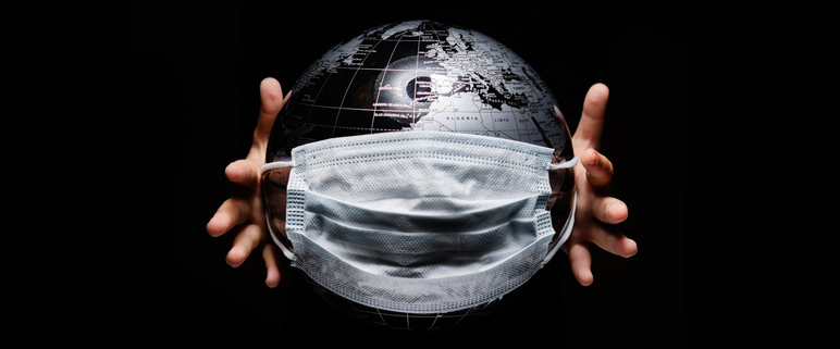 Hands holding globe isolated on black background. COVID 19 or ecological disaster concept