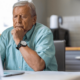 Senior man looking at a laptop wondering why he is losing senior living leads.