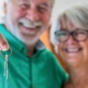 portrait and close up of Two happy seniors buying a new house holding the key with his hand.