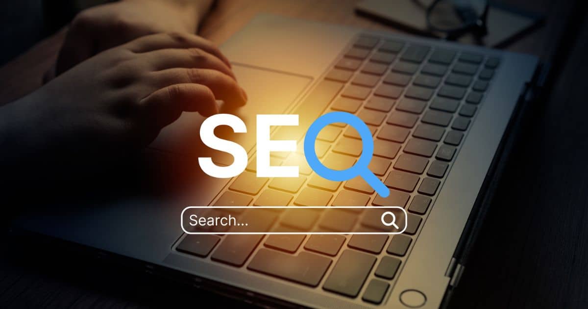 A person’s hand on a laptop keyboard with the text “SEO” and a search bar graphic overlayed on the image, highlighting seo for senior living strategies.