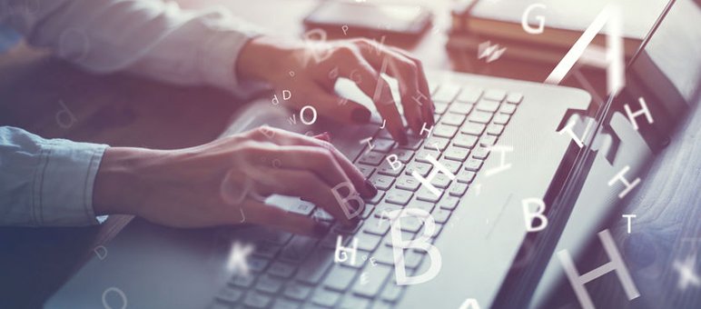 Hands typing on a laptop keyboard with scattered floating letters in the foreground, books and a smartphone in the background—perfect for creating engaging content for a senior living blog.