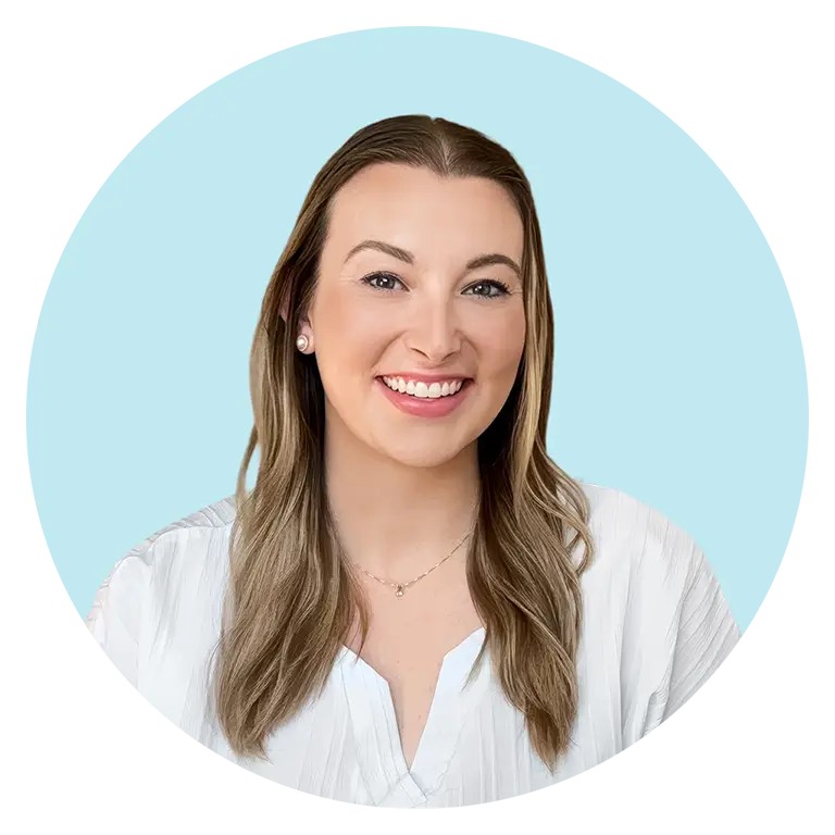 A woman with long, light brown hair and a white blouse smiles at the camera against a light blue background.