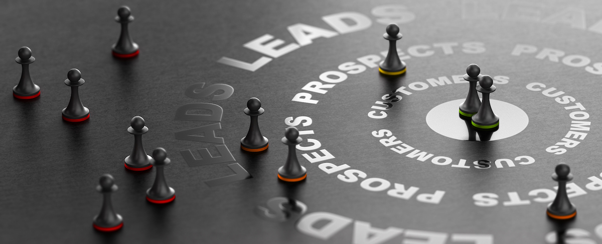 Silver game pieces are placed on a black surface with concentric circles labeled "LEADS," "PROSPECTS," and "CUSTOMERS," illustrating a sales funnel concept ideal for tracking senior living leads.
