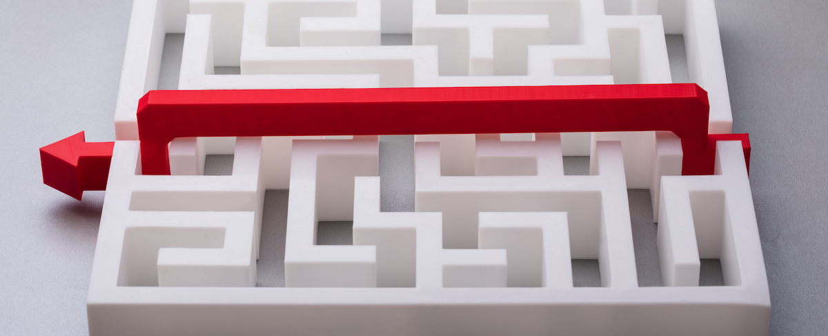 A red arrow placed over a white maze, showing a straight path that bypasses the maze’s twists and turns—symbolizing an easy solution to senior living sales challenges.