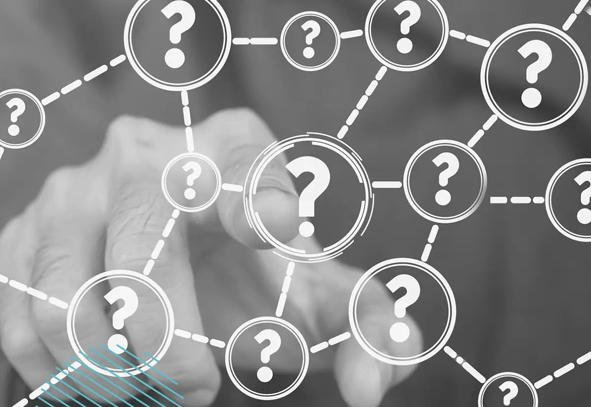 A hand points at a touchscreen displaying interconnected question marks, representing a network of queries or uncertainty.